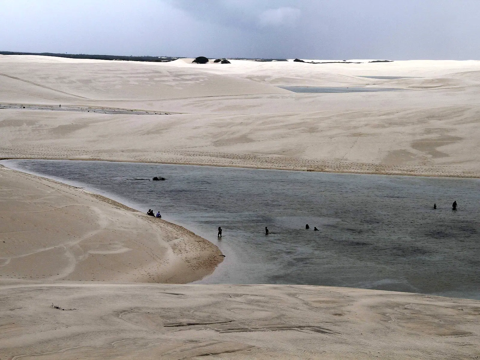 Visitantes se banhando na Lagoa Betânia, cercada por dunas